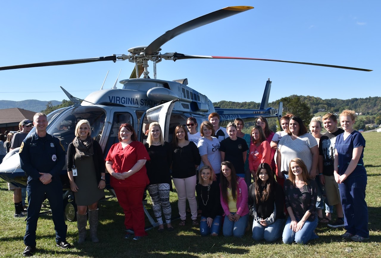 students in front of a helicopter