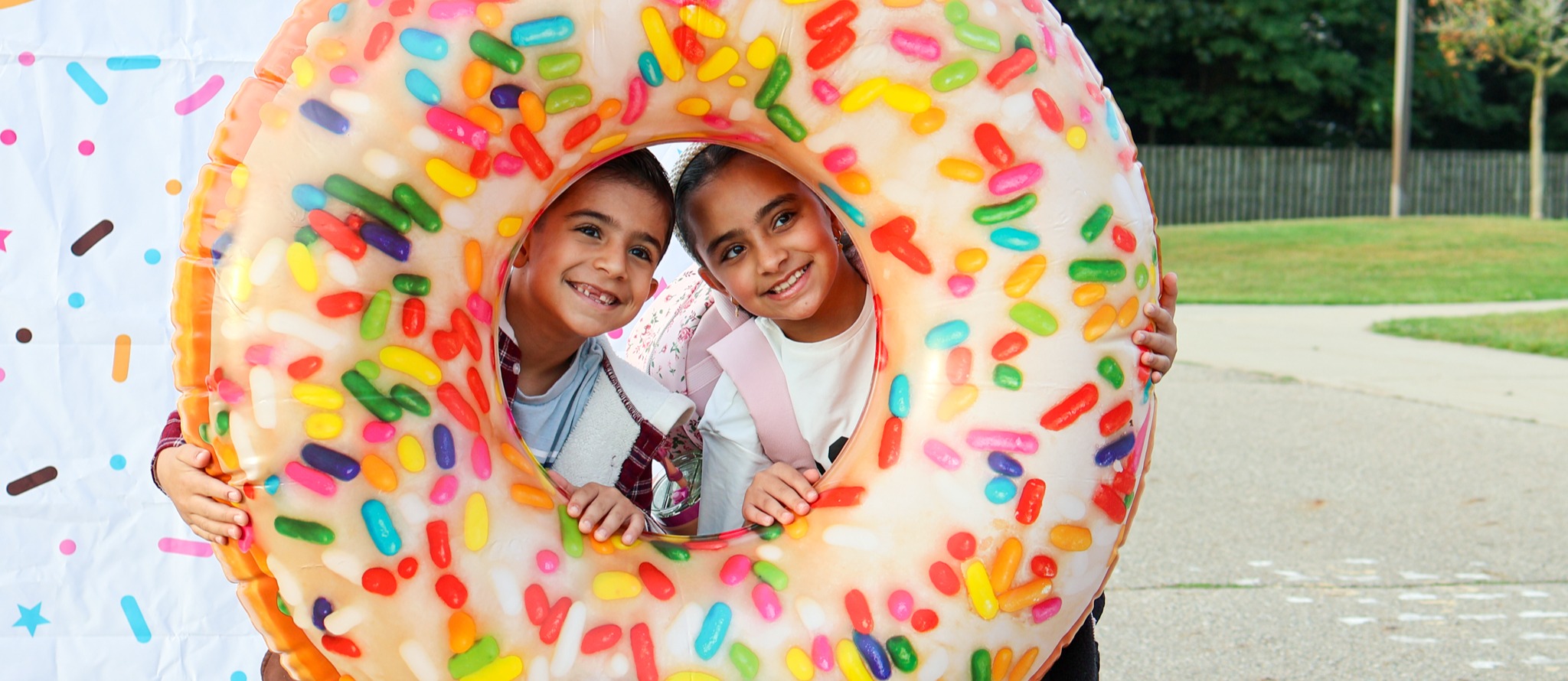 two students pose for a photo with an inflatable donut