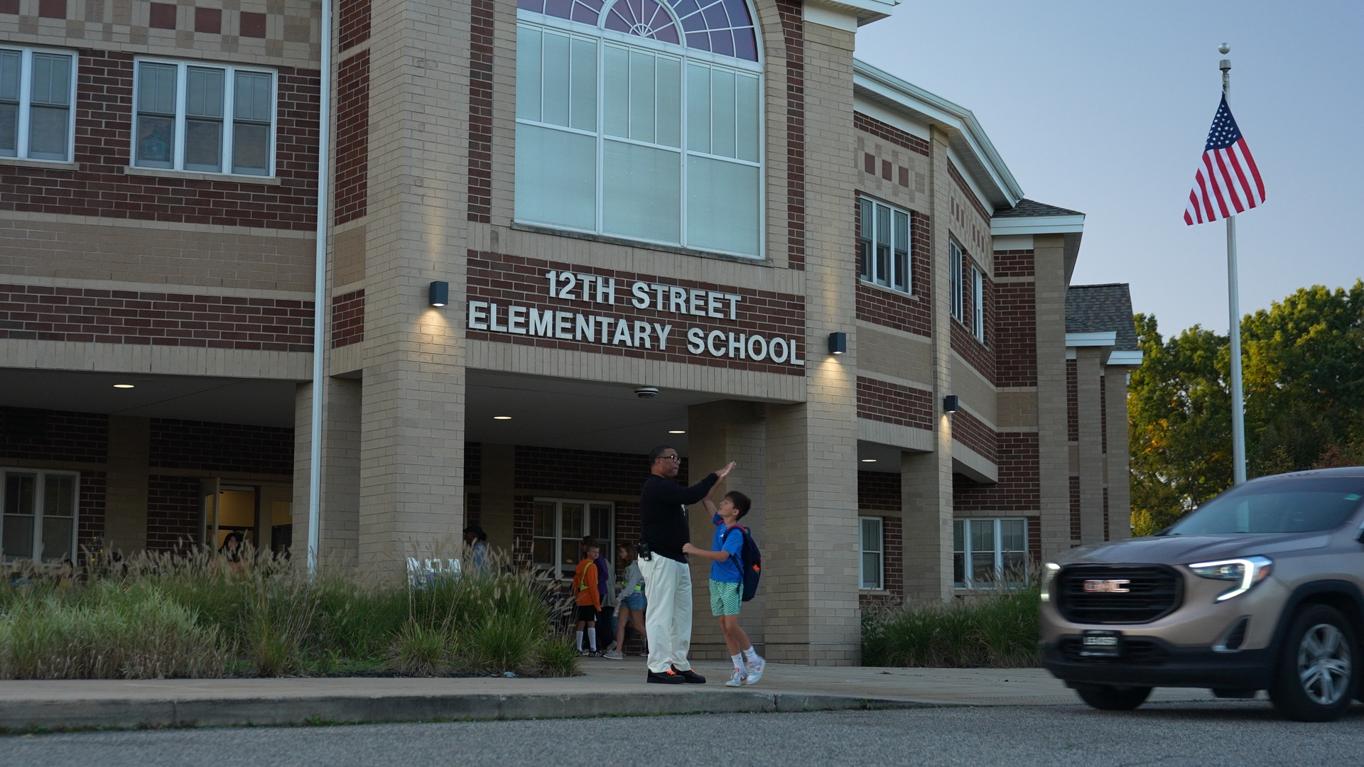 Mr. B high fiving a student getting dropped off