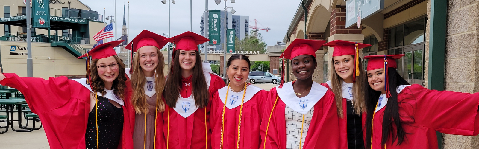 students in graduation caps and downs smiling