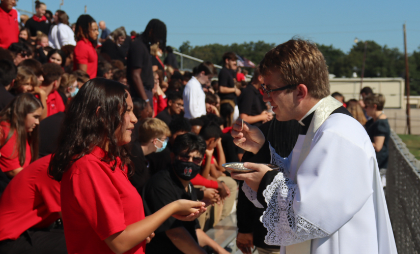 Fr. Patrick giving communion in the stadium outside