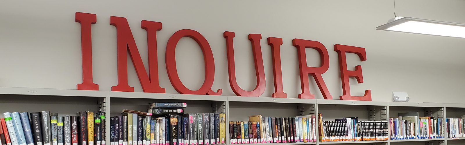 The word "Inquire" in red over a full bookshelf