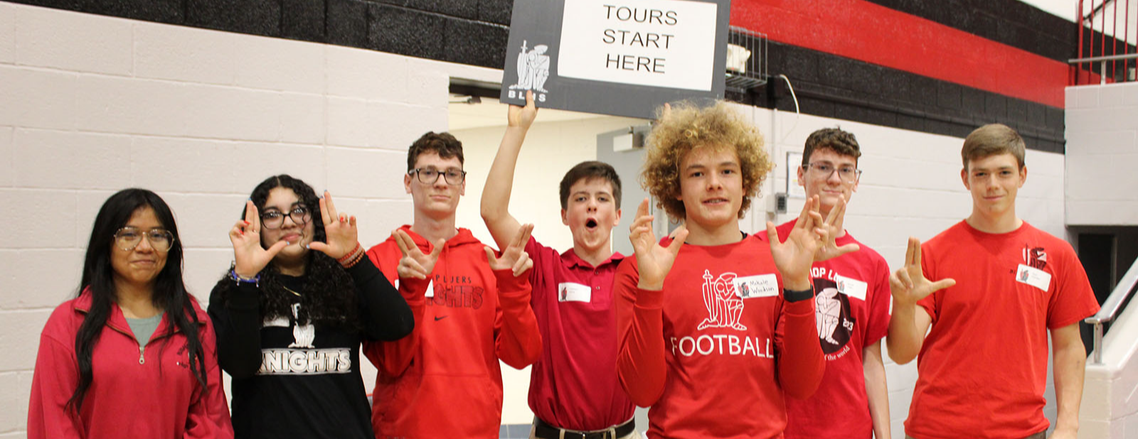 Smiling Luers students with a "Tours Start Here" sign