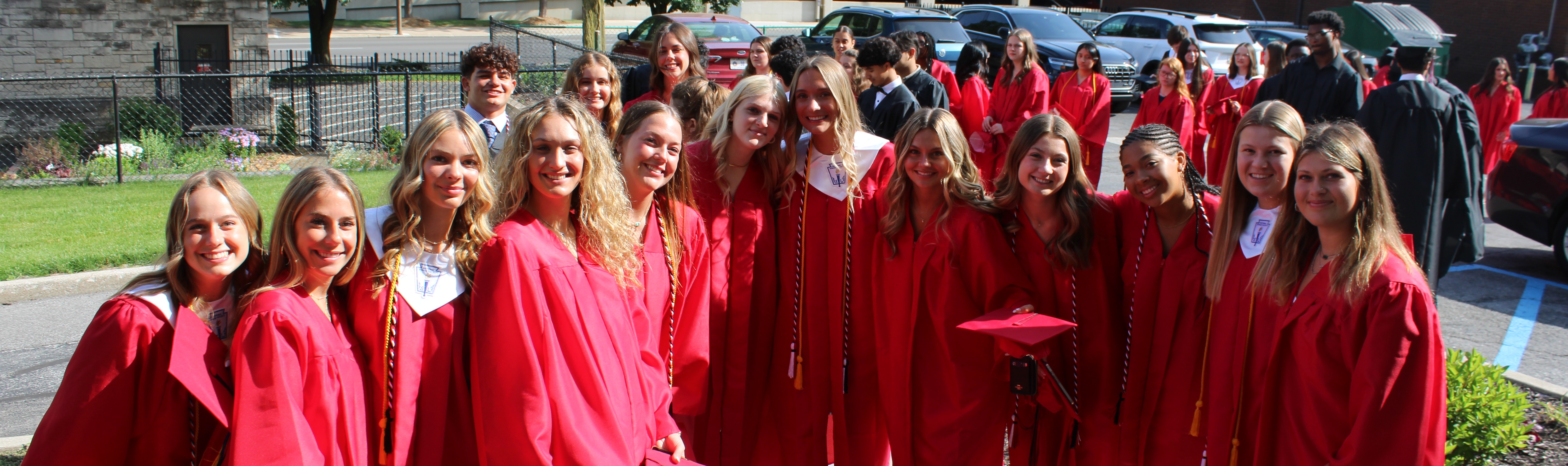 students in graduation caps and downs smiling