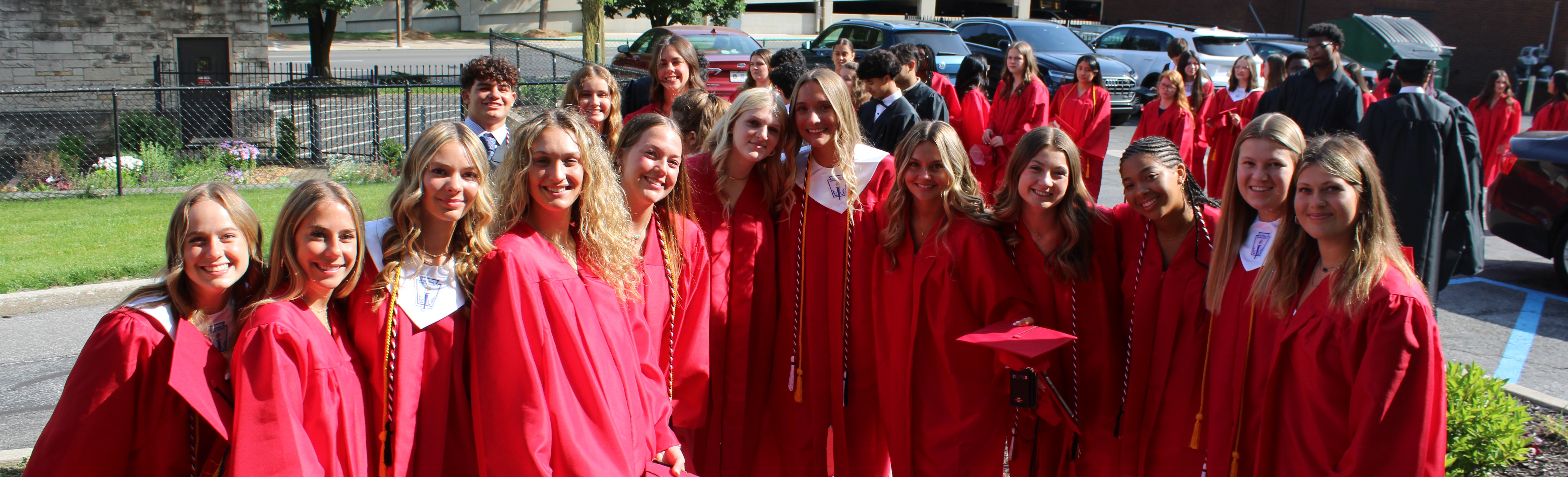 students in graduation caps and downs smiling