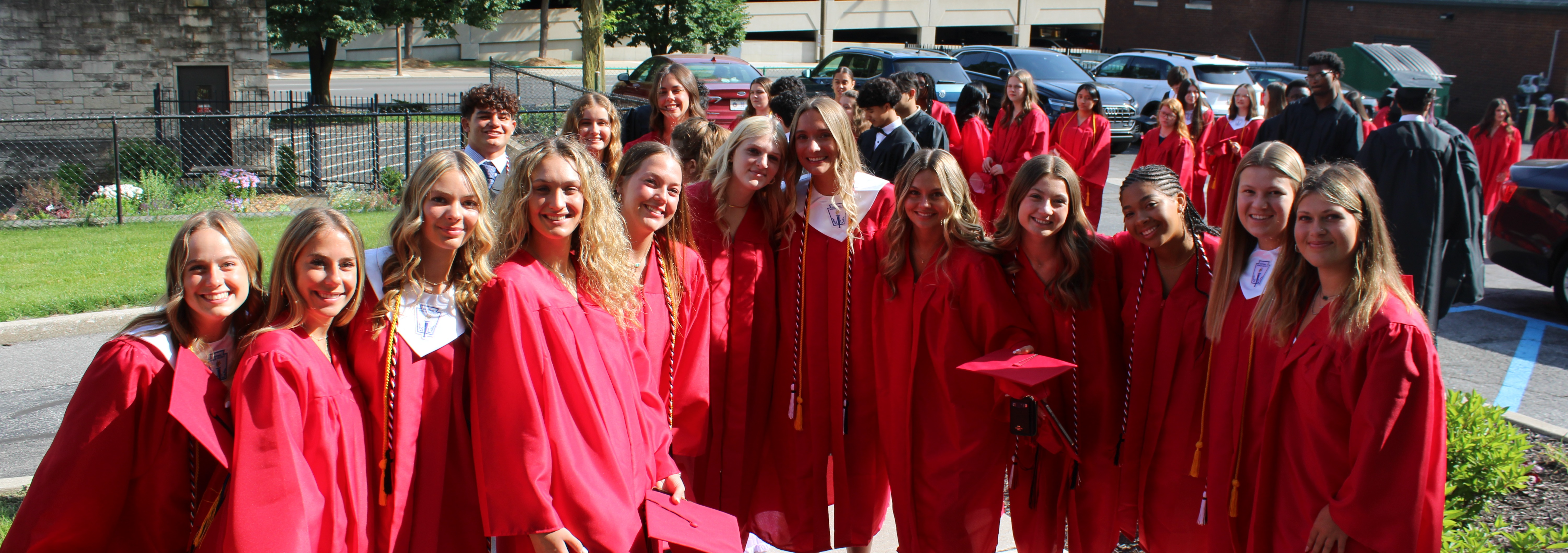 a large group of students smiling and holding "El espíritu Luers!/Luers Spirit!" banners