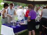 a woman in a purple shirt talking to two women at a booth