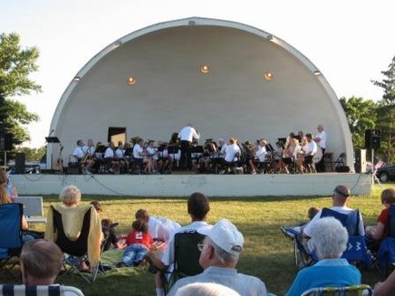 The Lennox Municipal band playing in a park under an awning