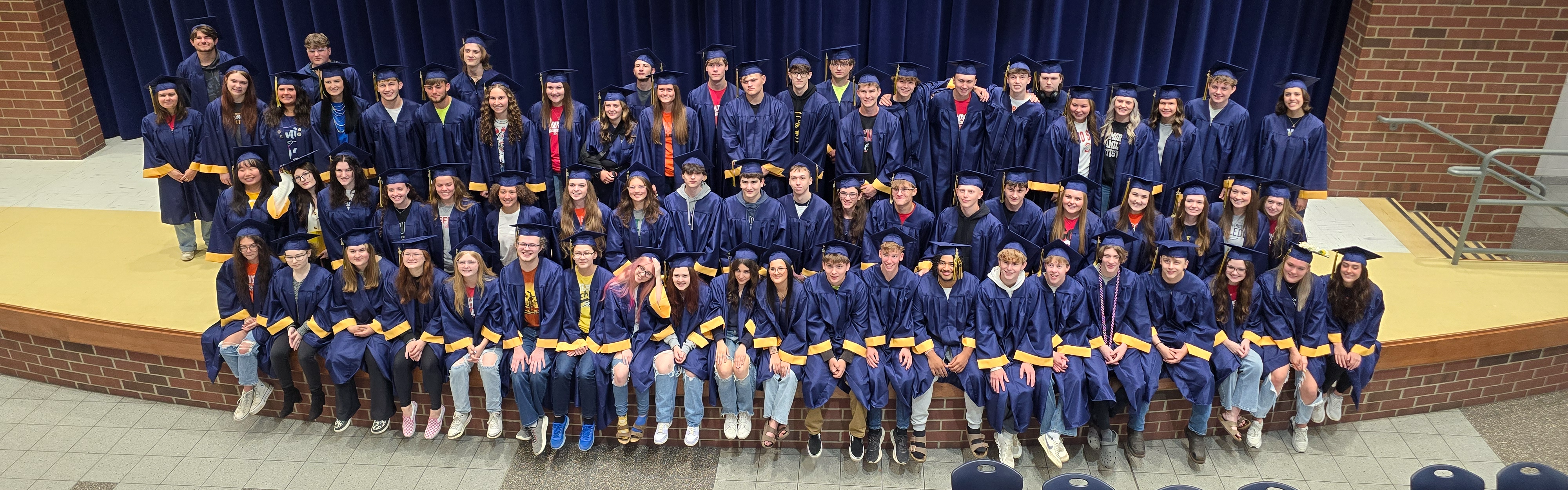 Class of 2025 poses for a picture on the stage after doing their clapout at the elementary and middle schools.