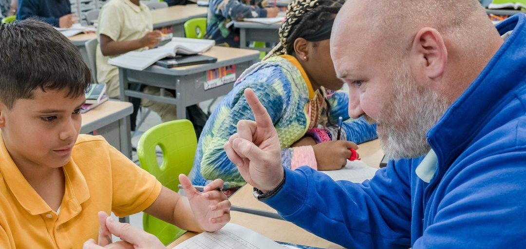 Teacher assisting student with classroom activity