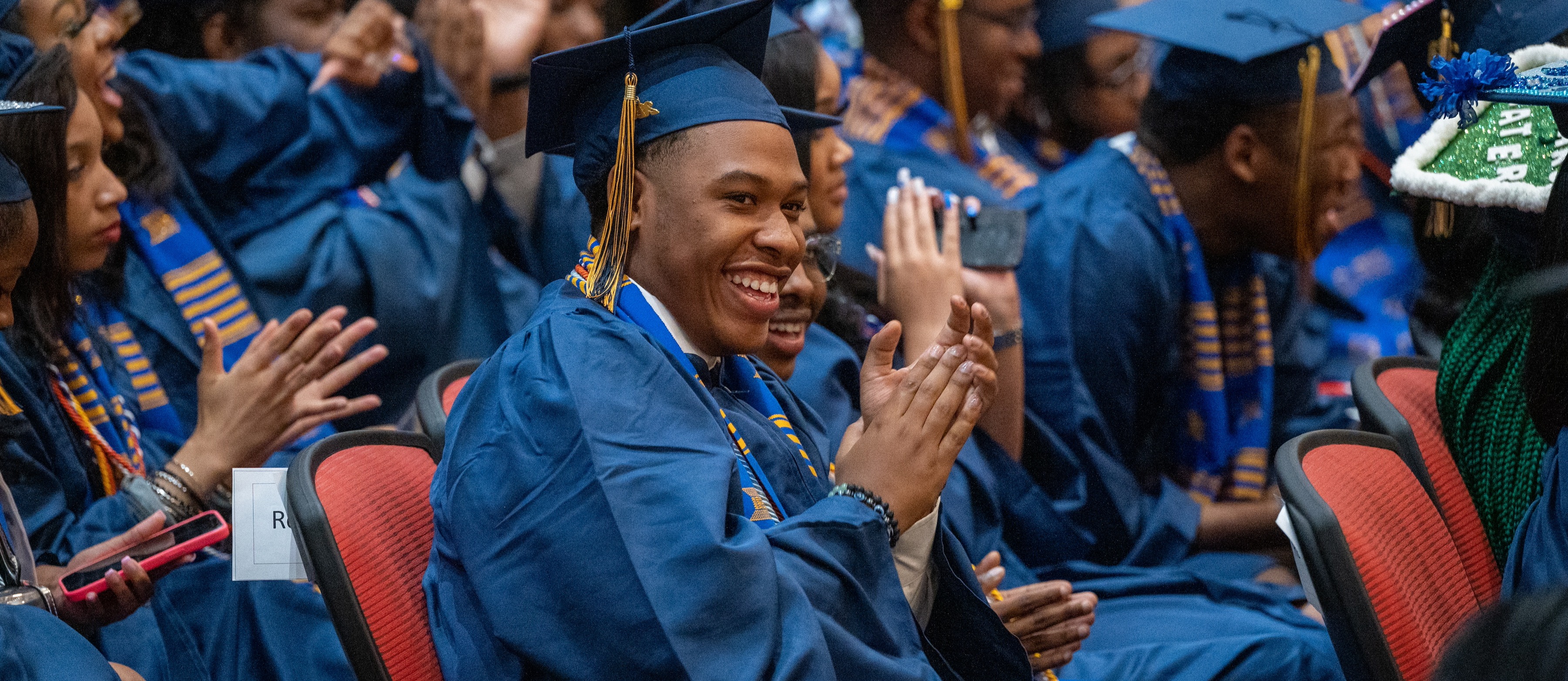Coppin Academy student applauds during his 2023 graduation ceremony.