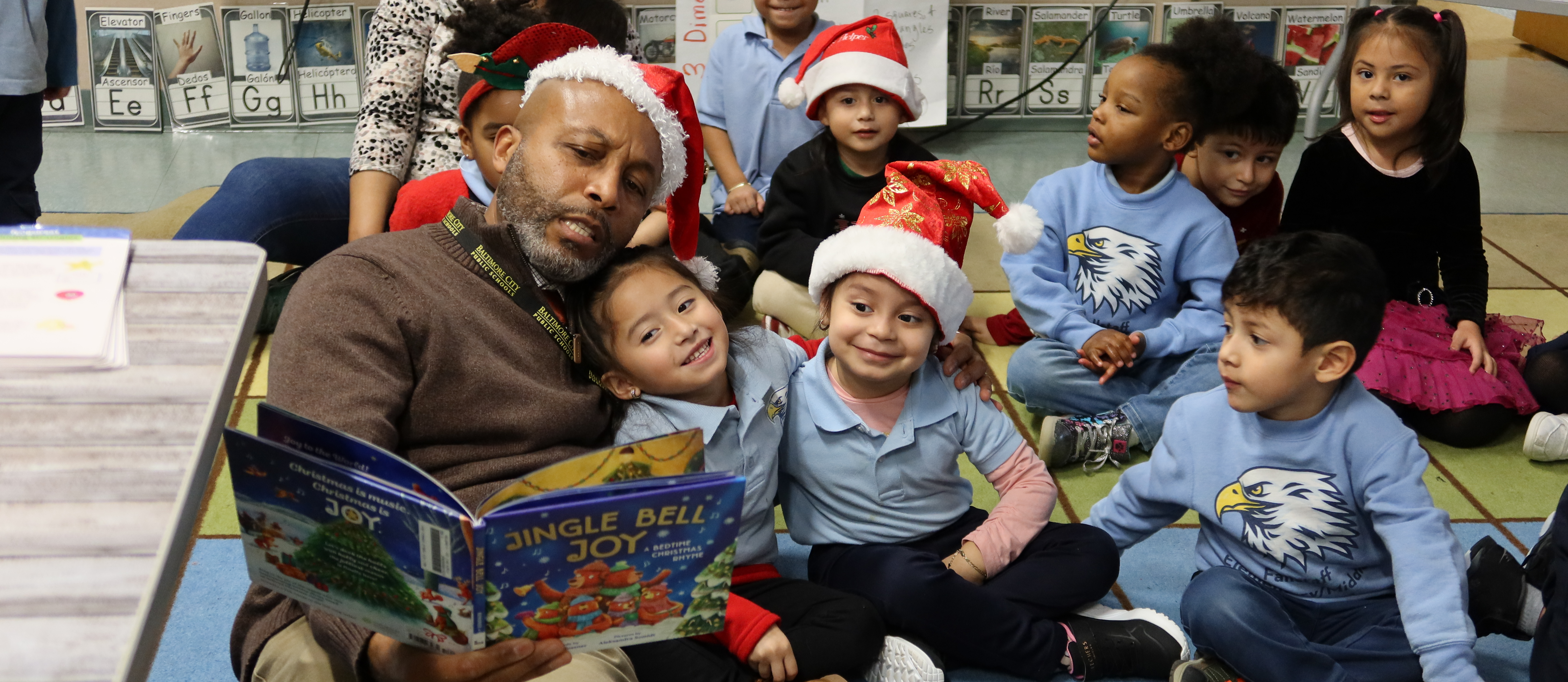 Staff member reads to Fallstaff Elementary students at the Distinguished Men of Honor event.