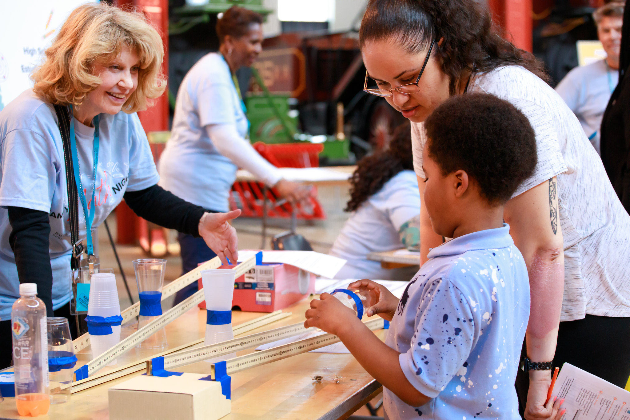 Woman helps students complete science experiment at the Maryland Science Museum