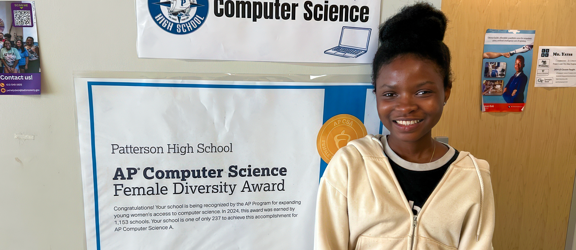 Patterson student stands next to women in STEM award
