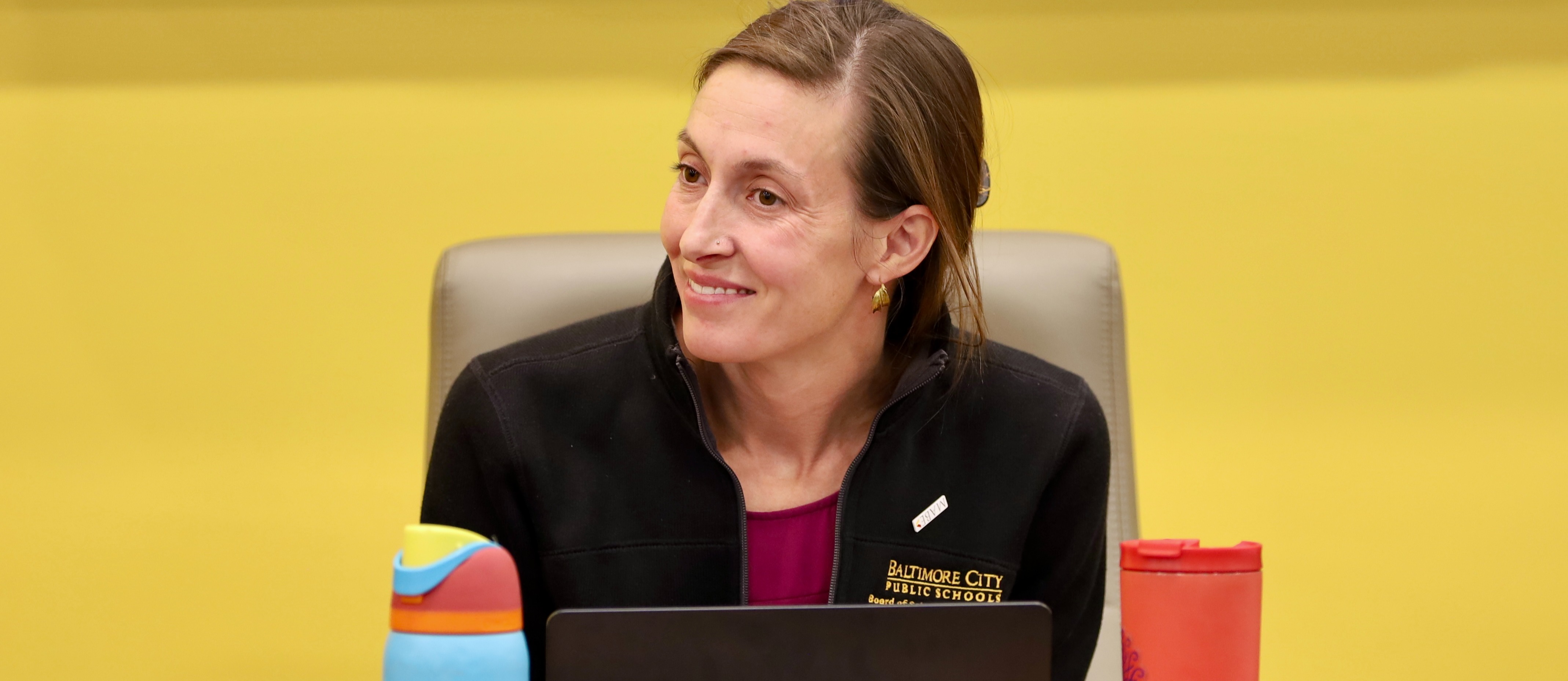 Board Commissioner smiles at a speaker during a meeting. 