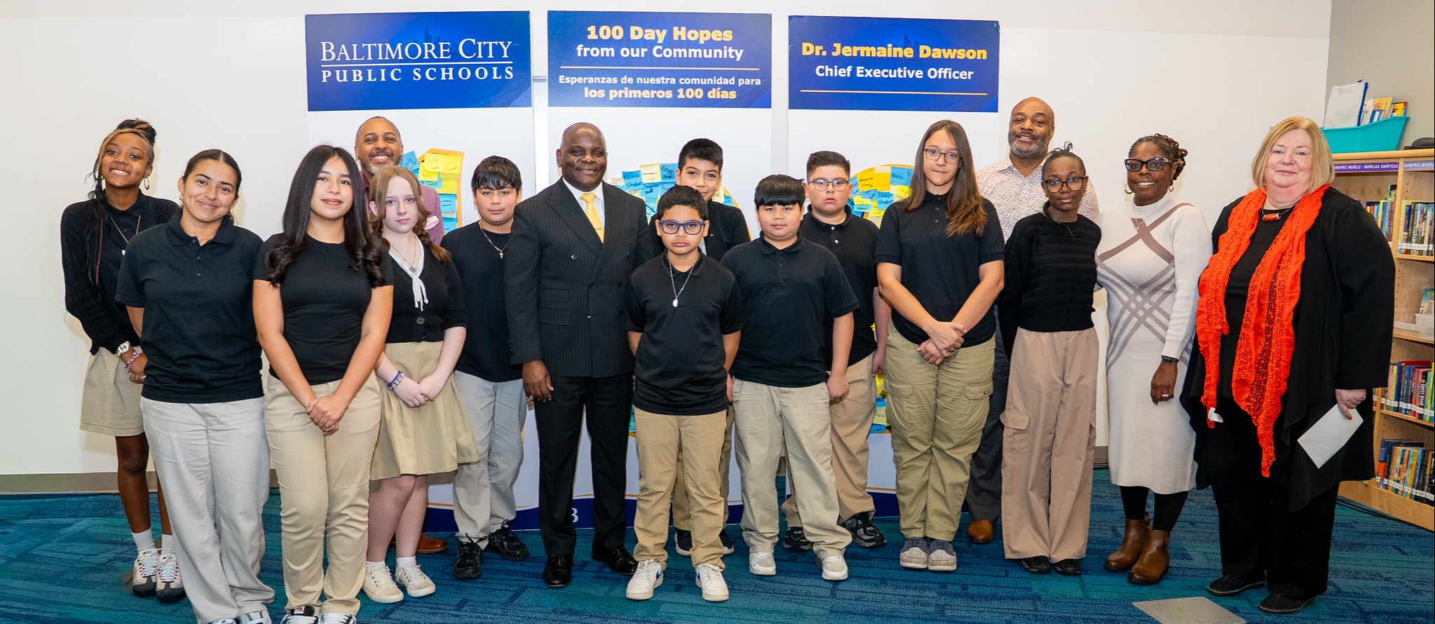 Dr. Dawson, students, and staff stands for photo in front of 100 day art installation 