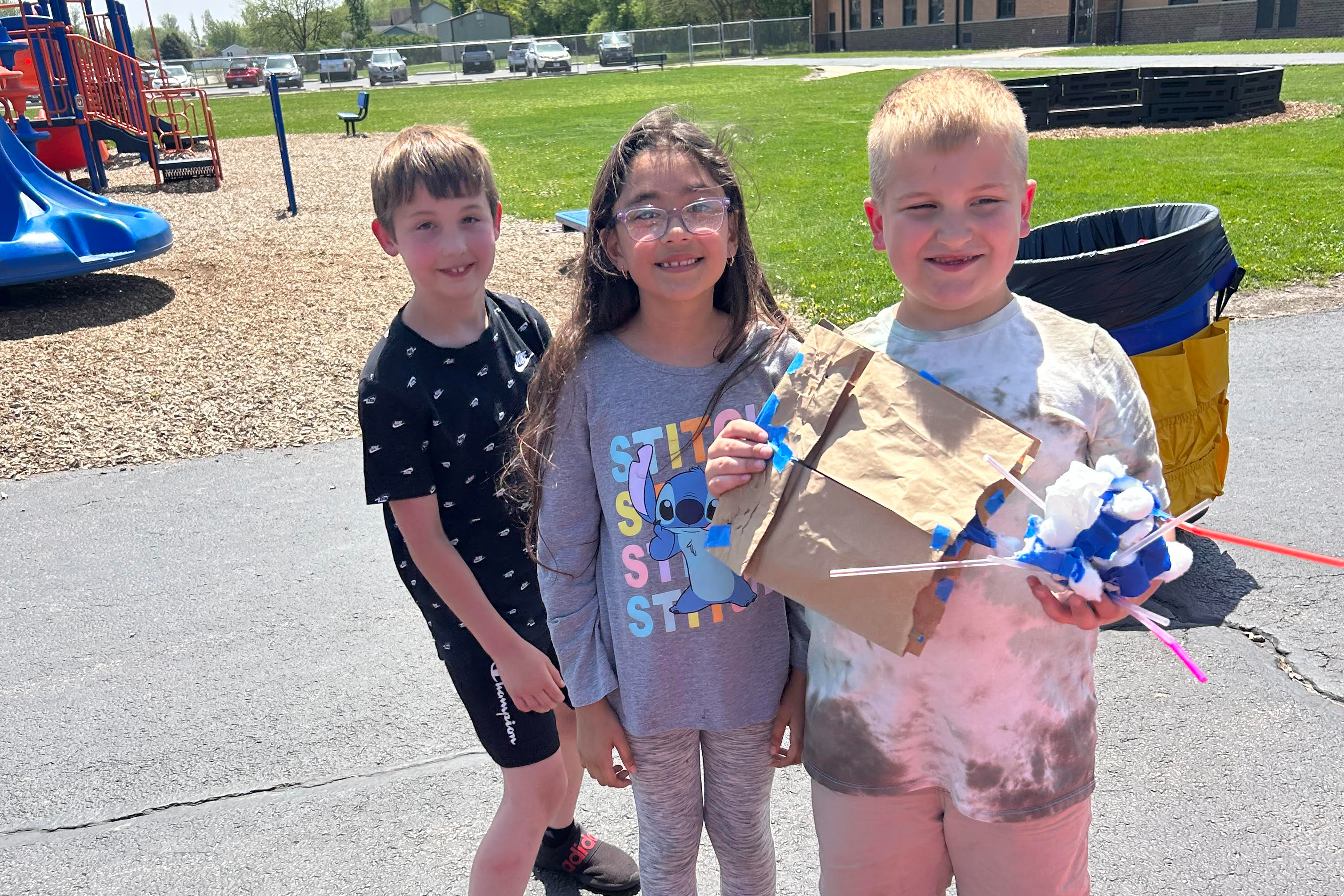 image of students holding an egg drop science experiment