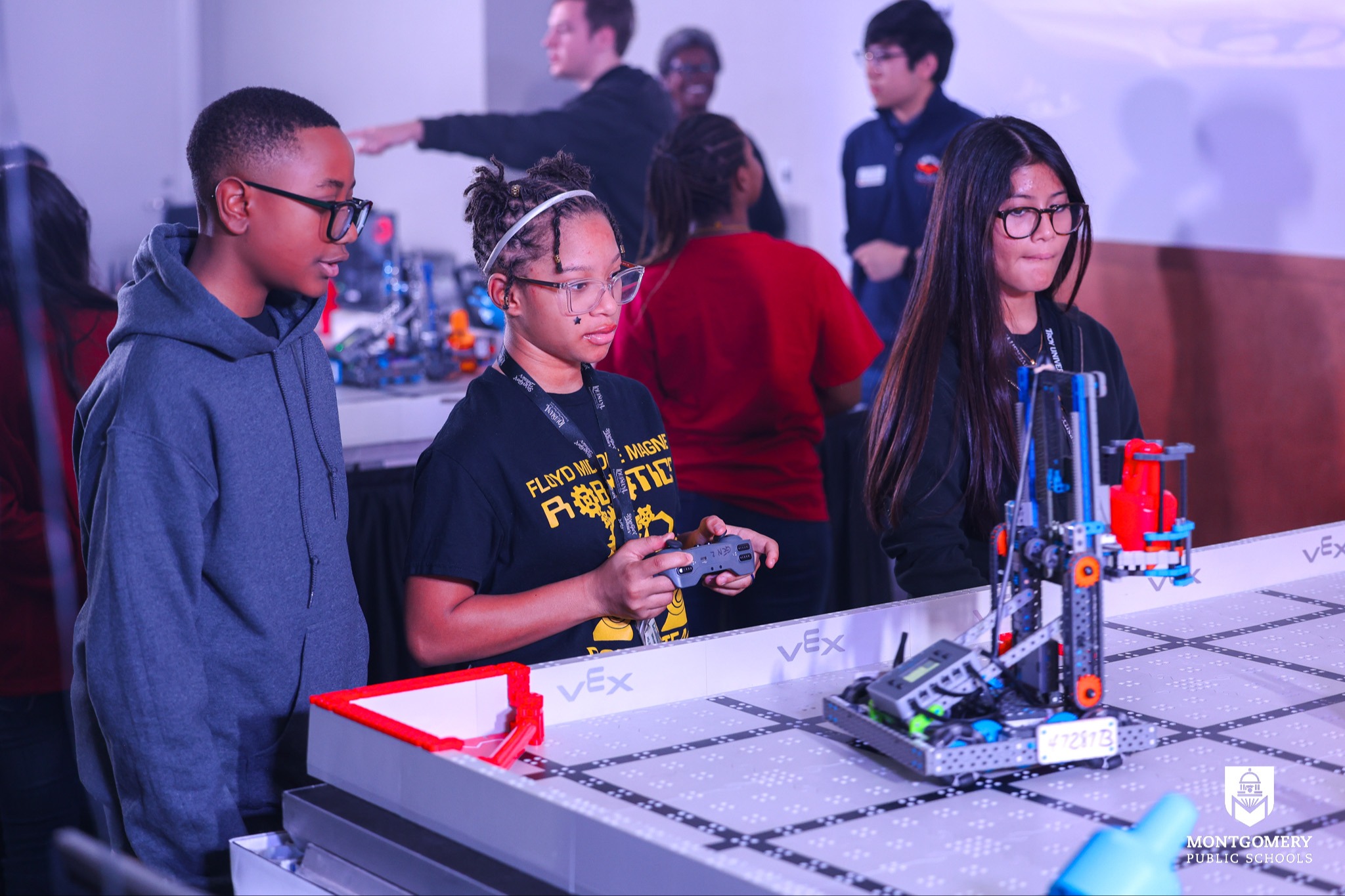 Three students together in a robotics competition