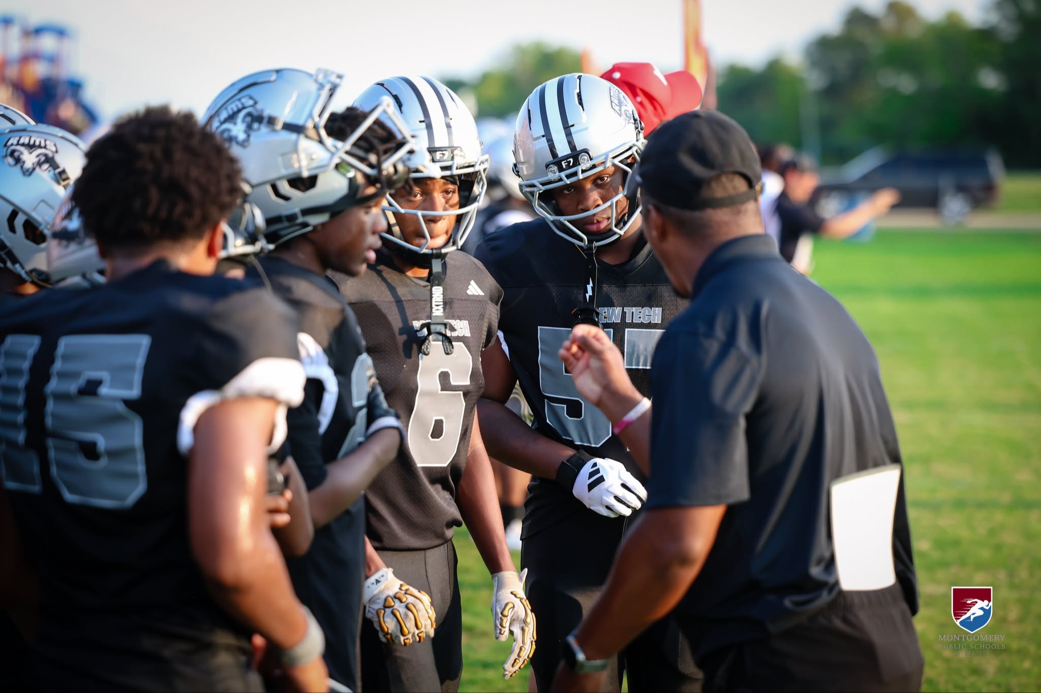 Coach Coaching Players In Huddle