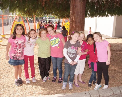 students take group photo outside playground