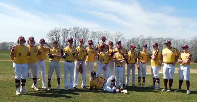 baseball team stands shoulder to shoulder in yellow uniforms