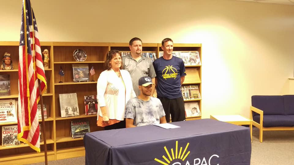 Photo of Jimmy Schroeder signing for cornerstone university for boys basketball