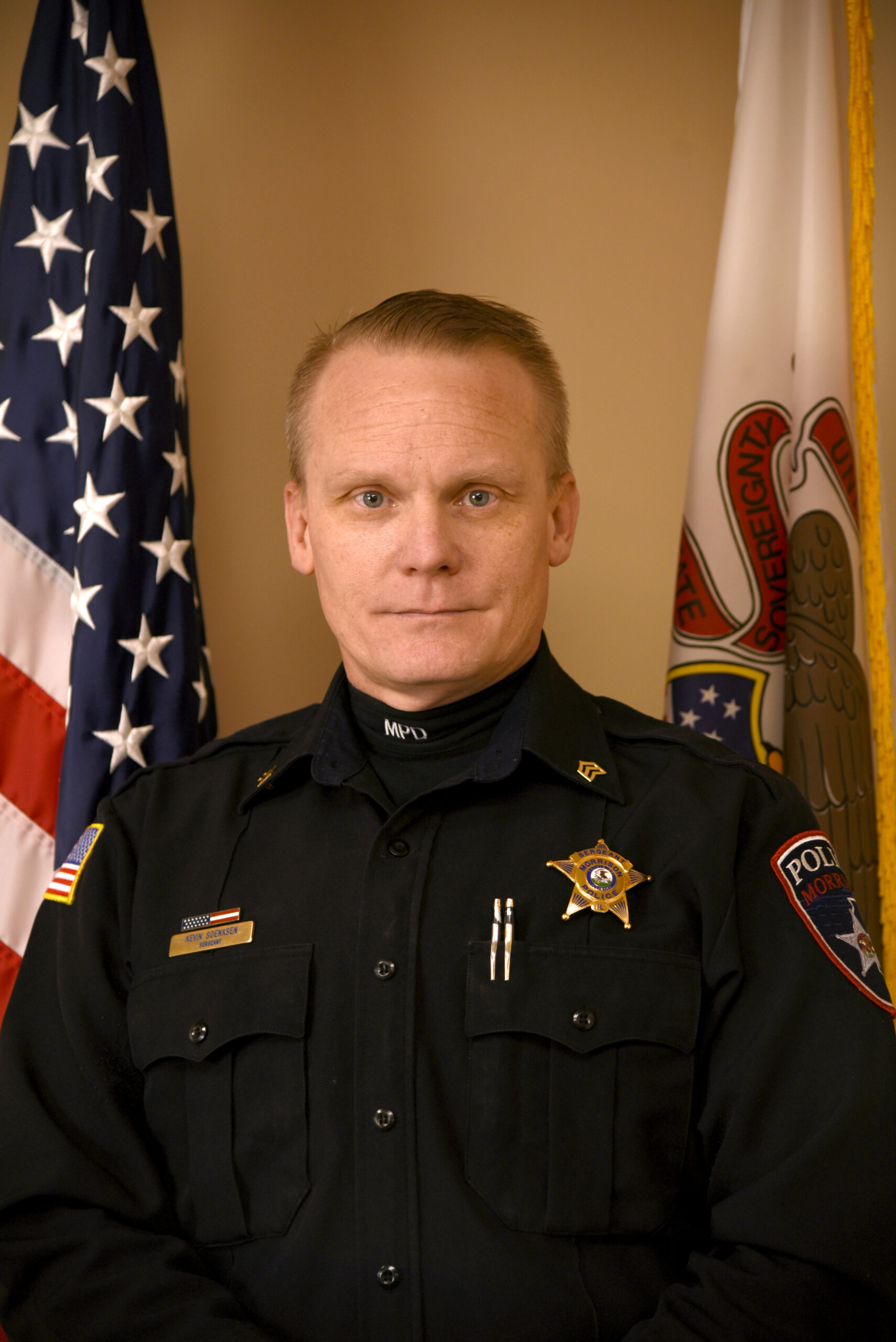 image of police officer standing in front of the USA flag