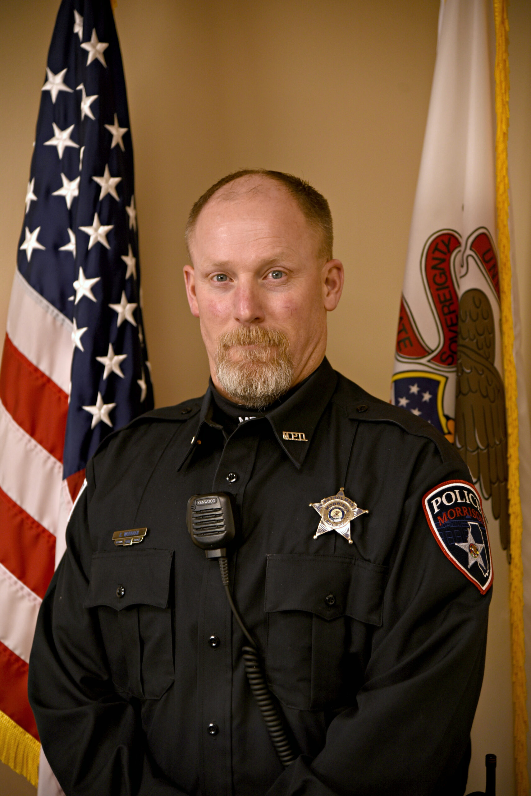 image of police officer standing in front on the American flag