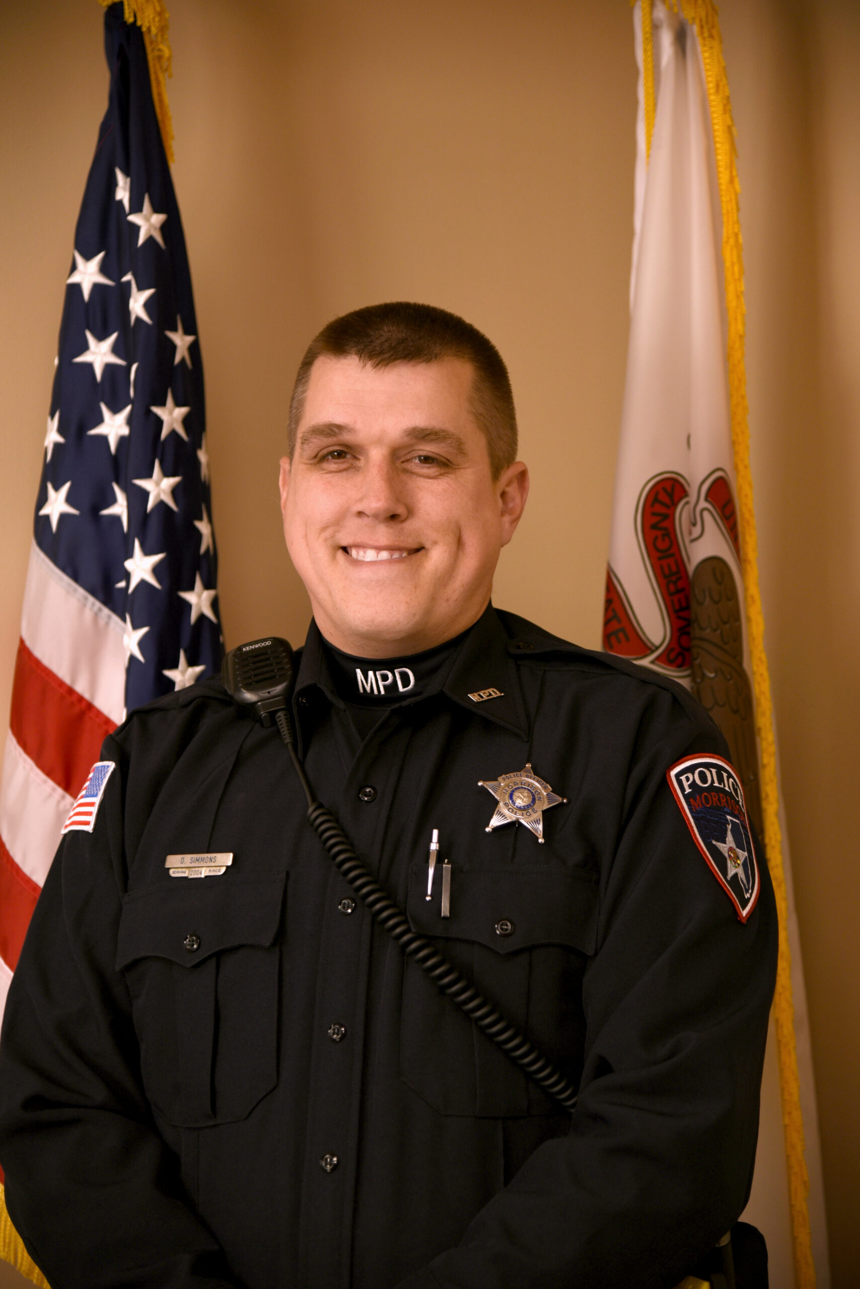 image of a police officer standing in front of the American flag