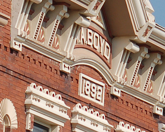 close up of the front of a red bring building that has 1892 in white letters above the windows