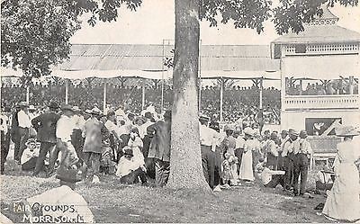 black and white photo of crowd surrounding stands at fairground