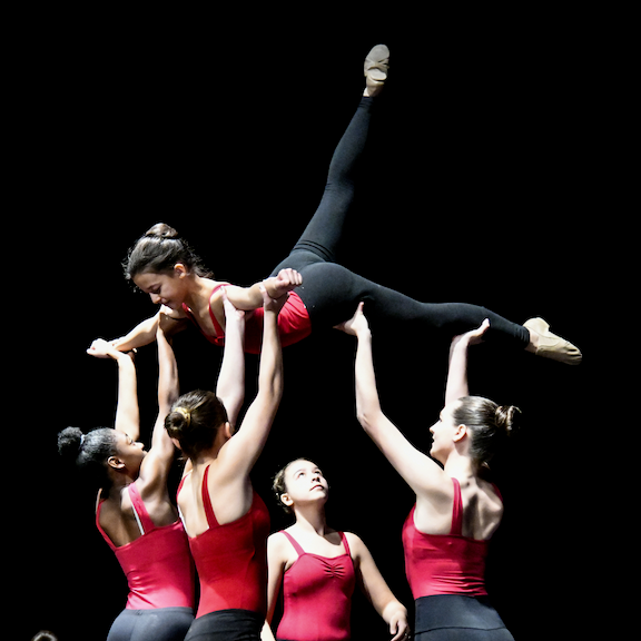 dancers holding girl in air