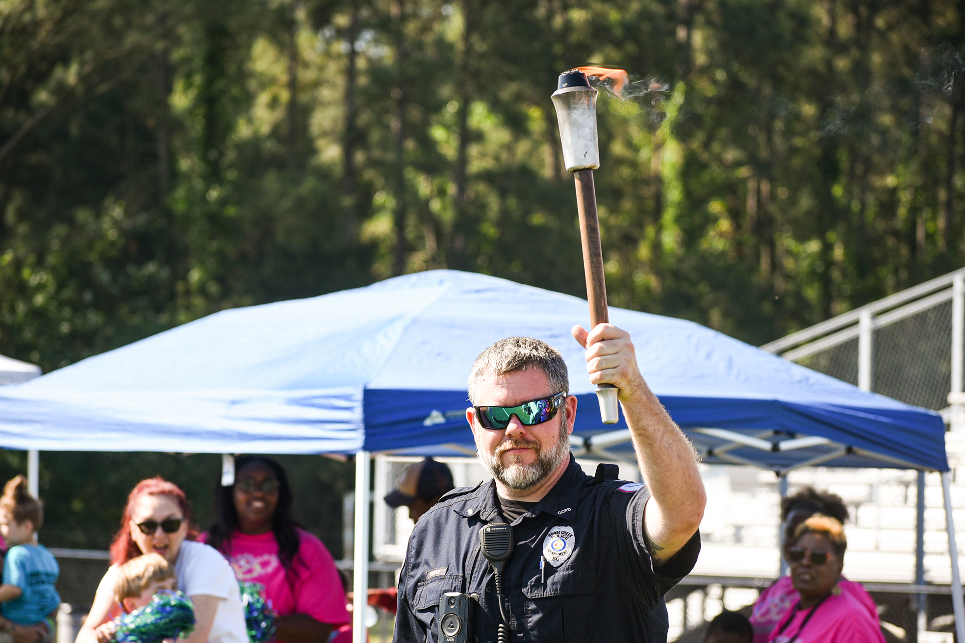 Lt Coffey holding up lit torch