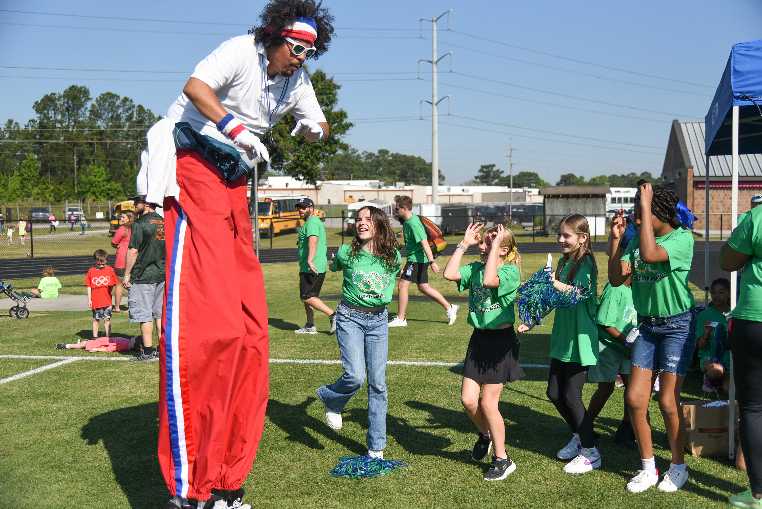 man on stilts talking to kids