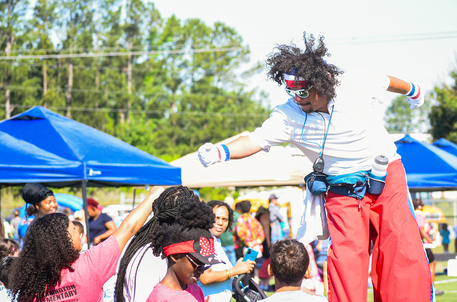 man on stilts giving woman fist bump