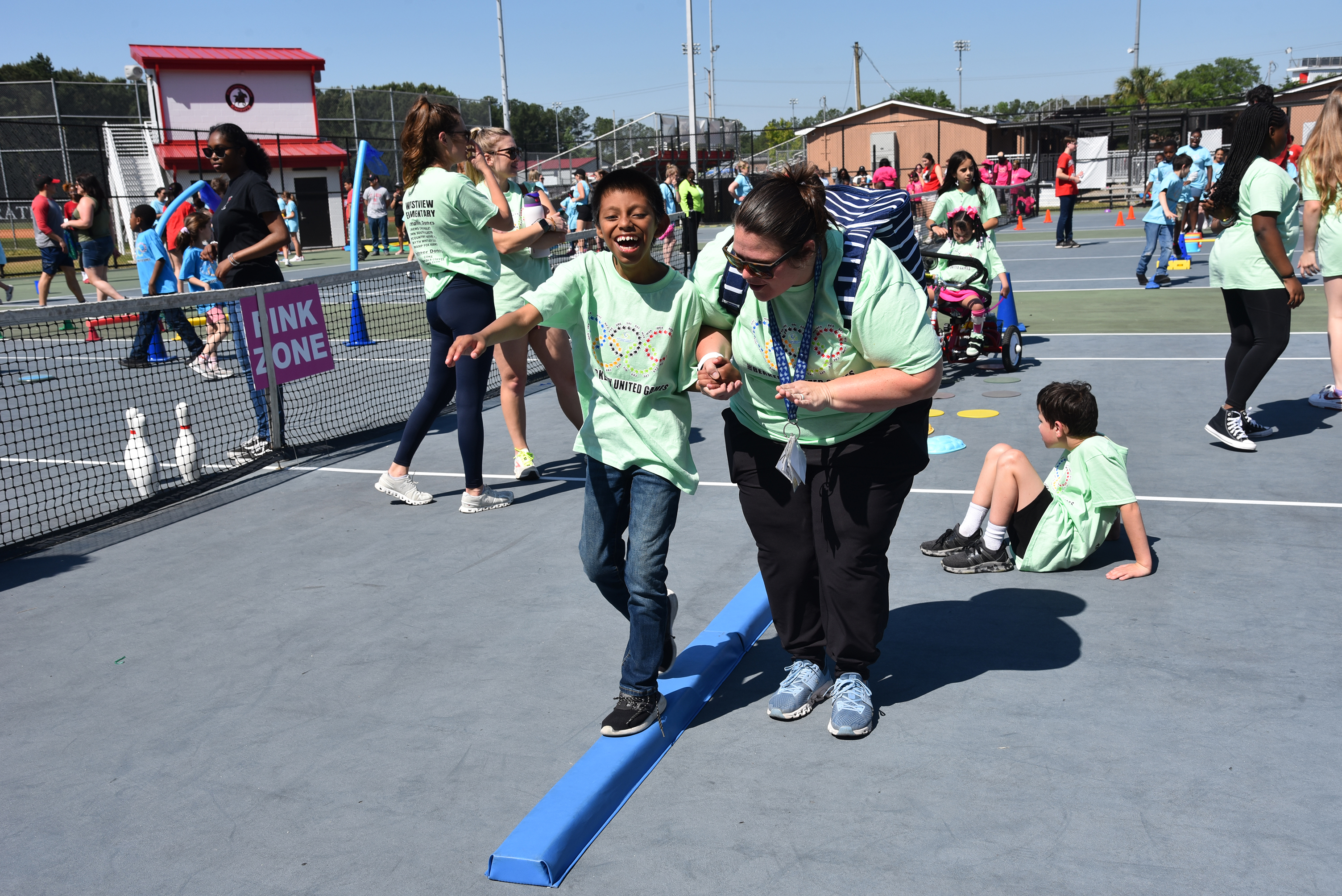 students in light green shirts laying games