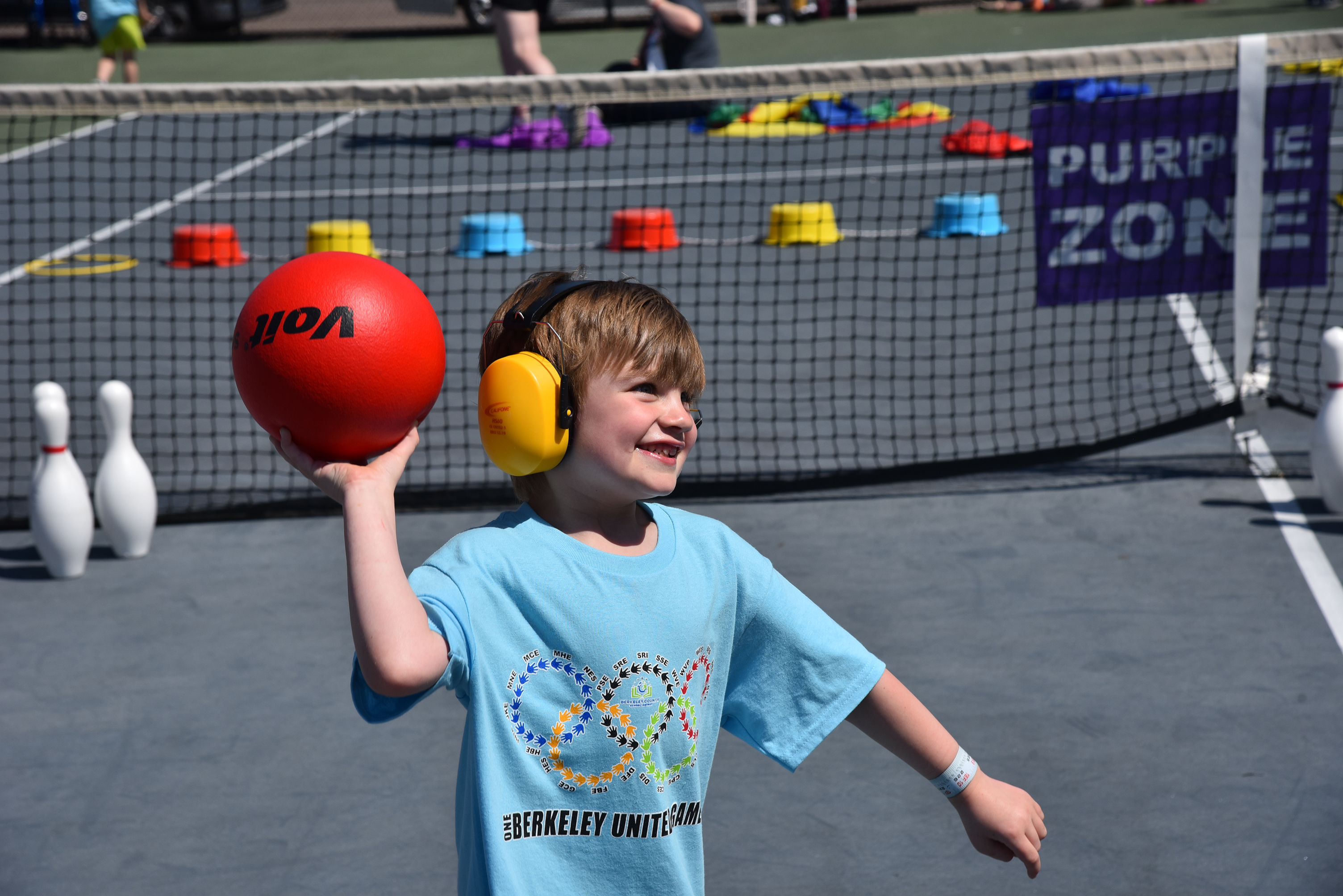 student in light blue shirt throwing ball