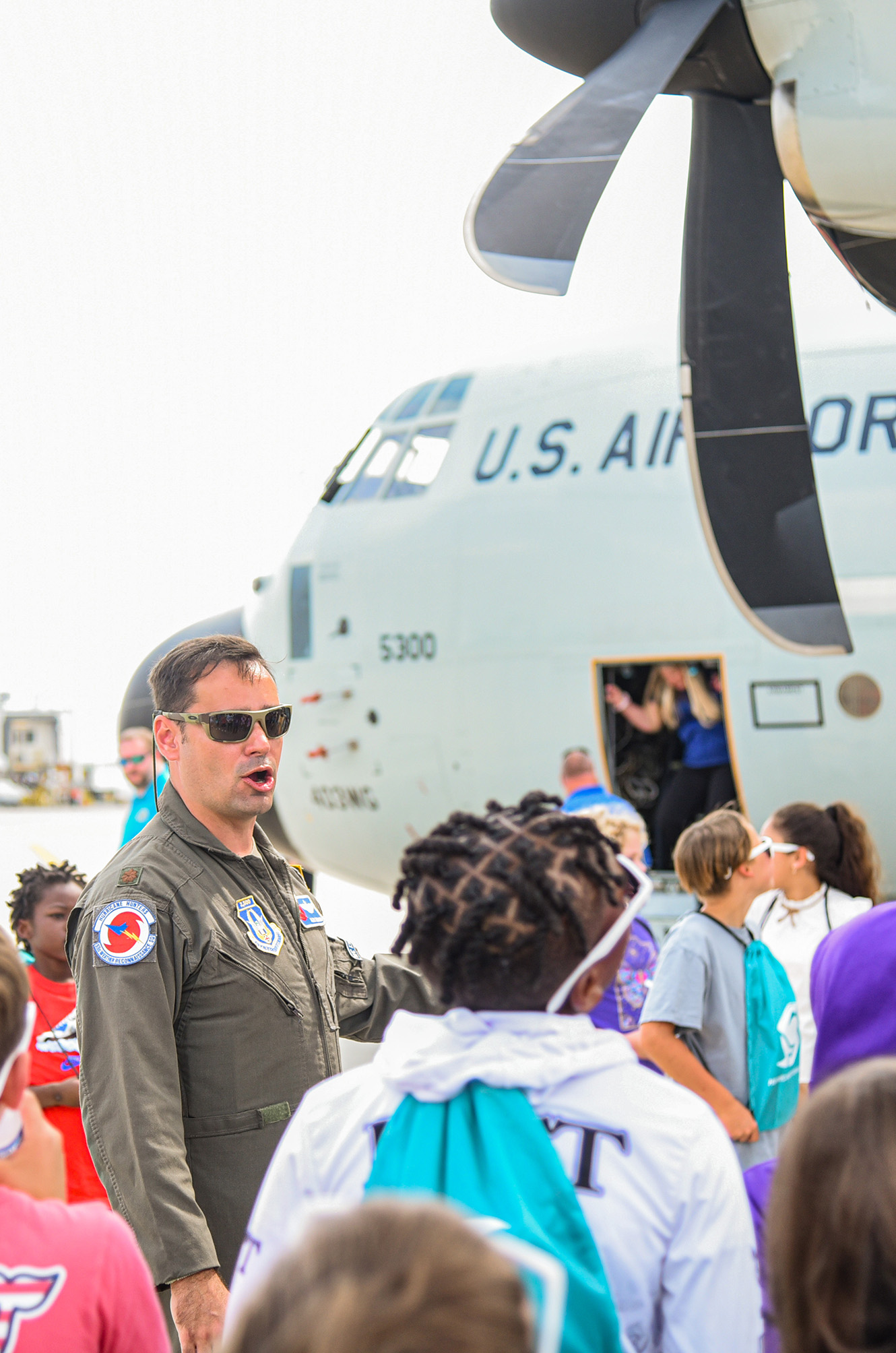 students gathering under plane's wing