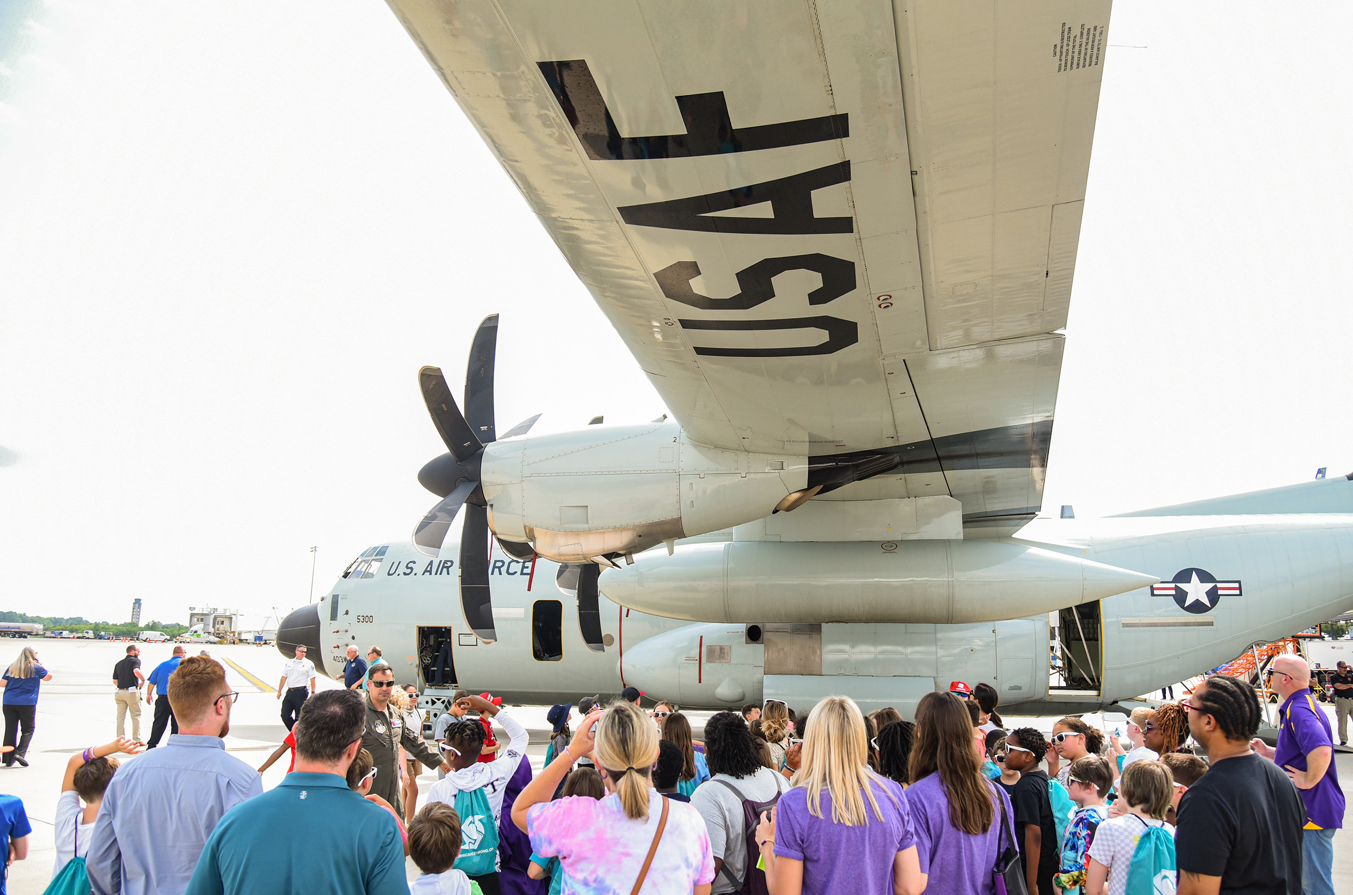 students gathering under plane's wing