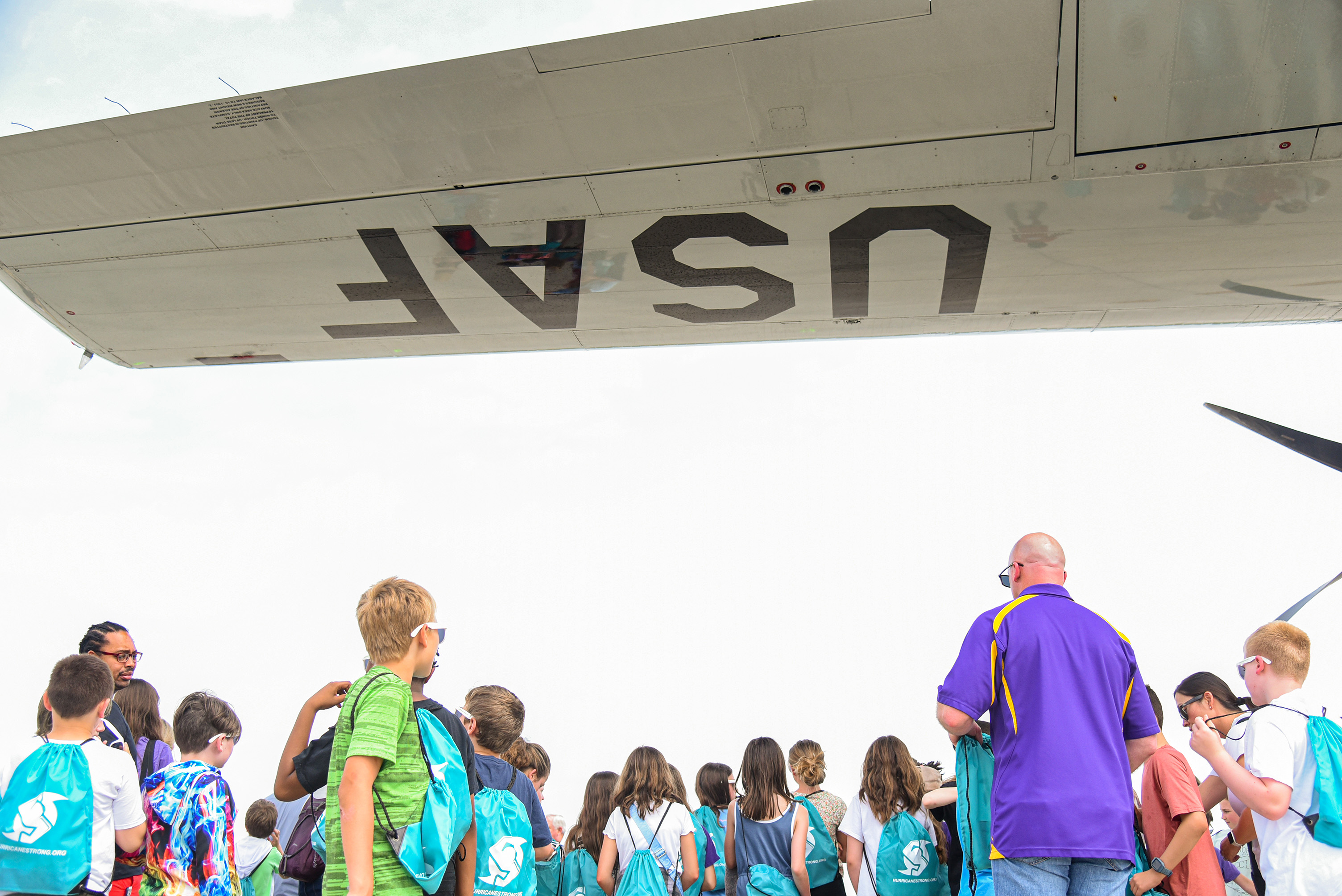 students gathering under plane's wing
