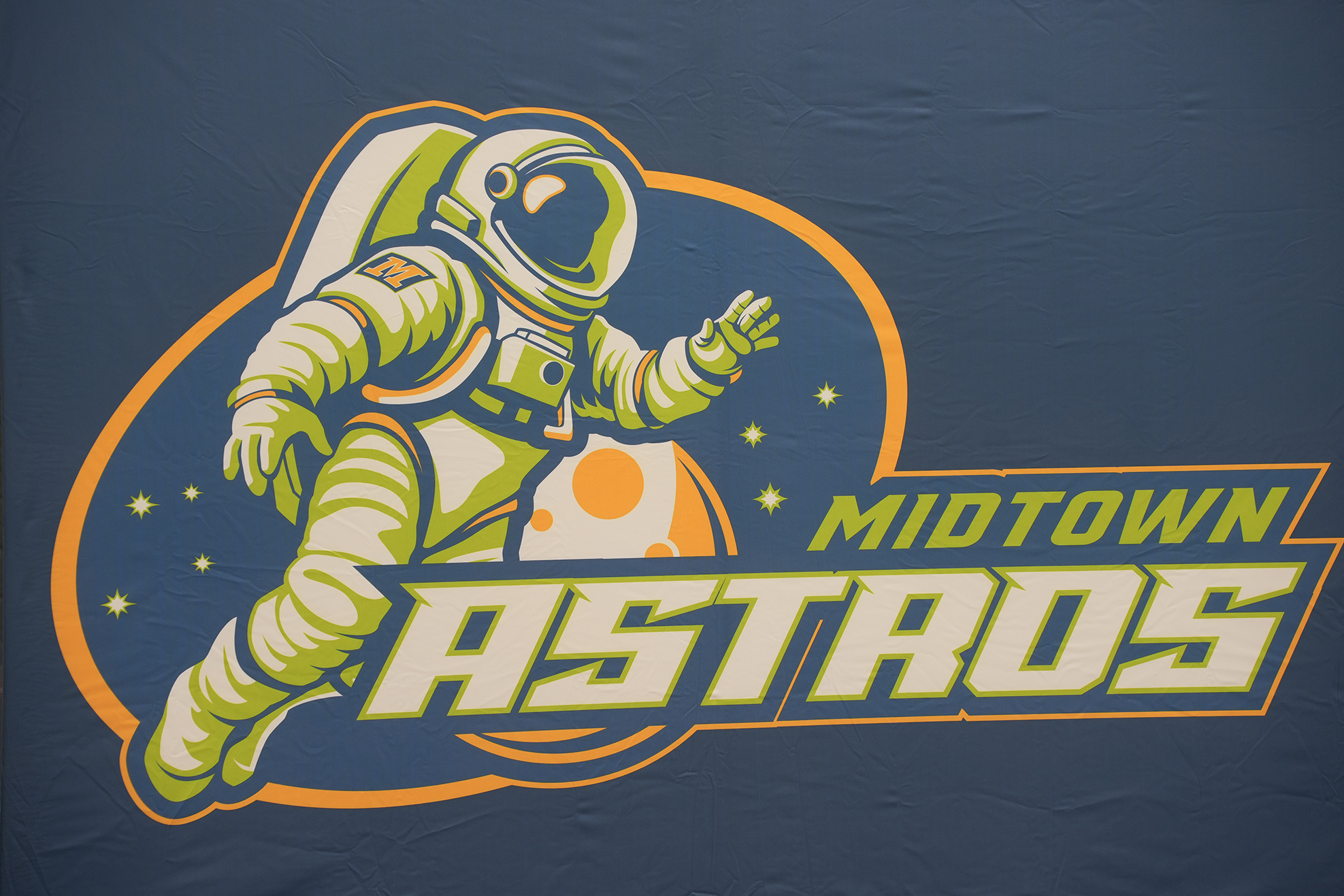 Logo featuring an astronaut floating with a helmet on, set against a dark blue background. "MIDTOWN ASTROS" text in green and orange is below.