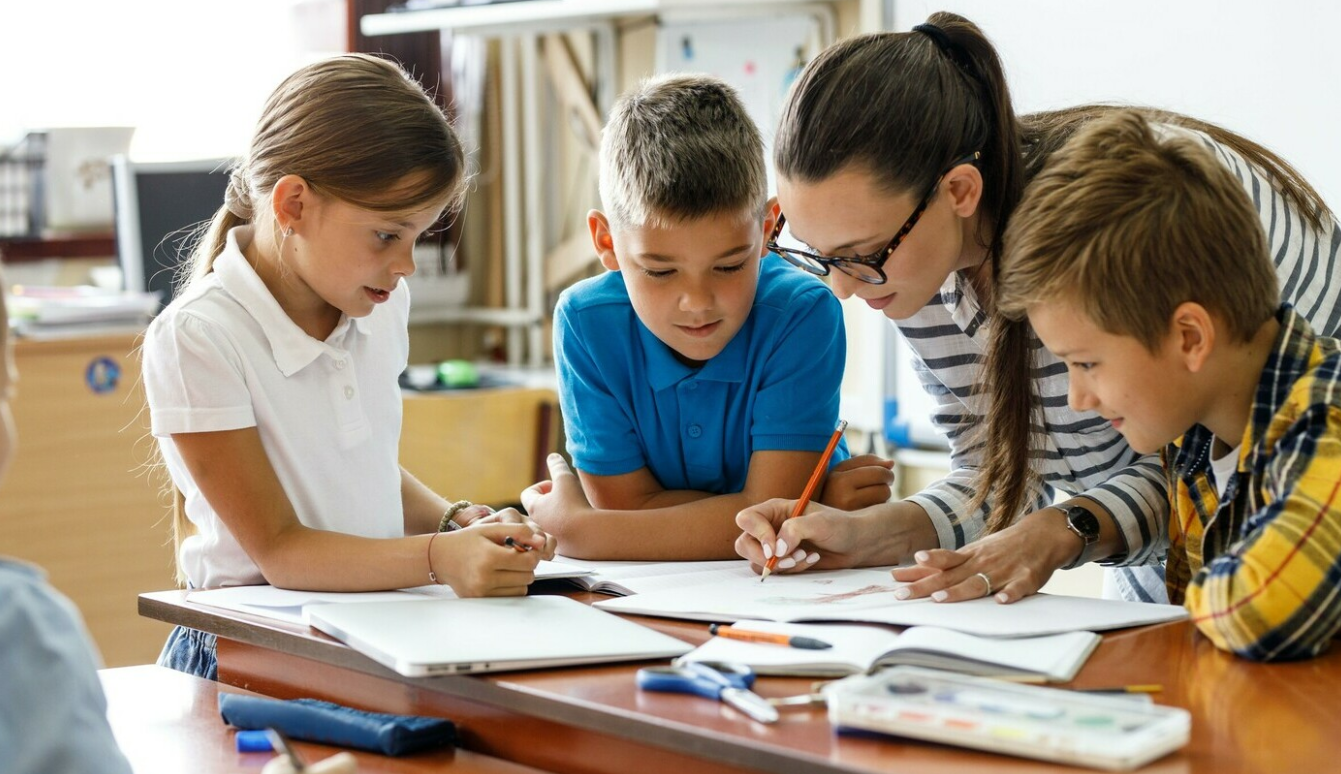 A teacher helping 3 students