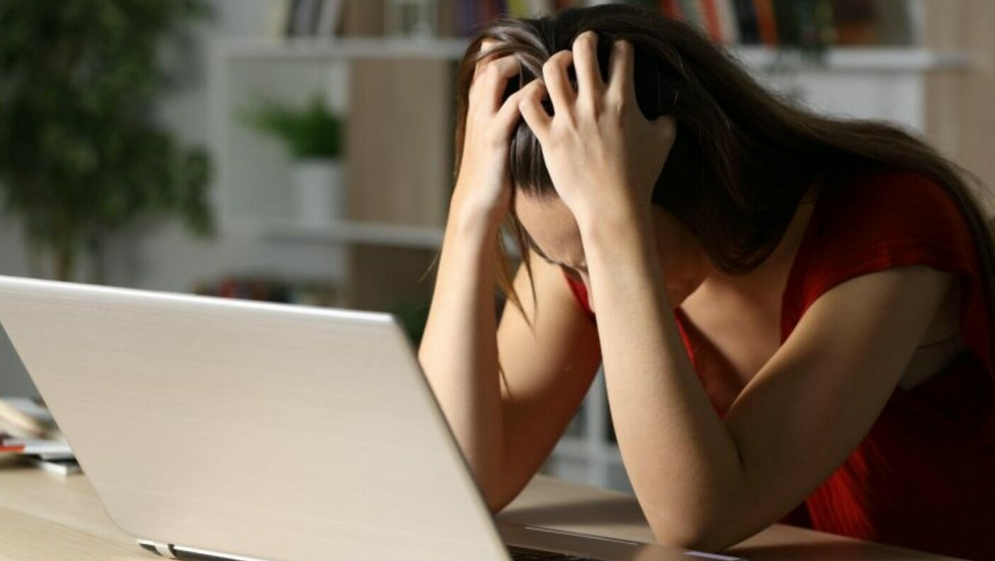 person sad next to laptop