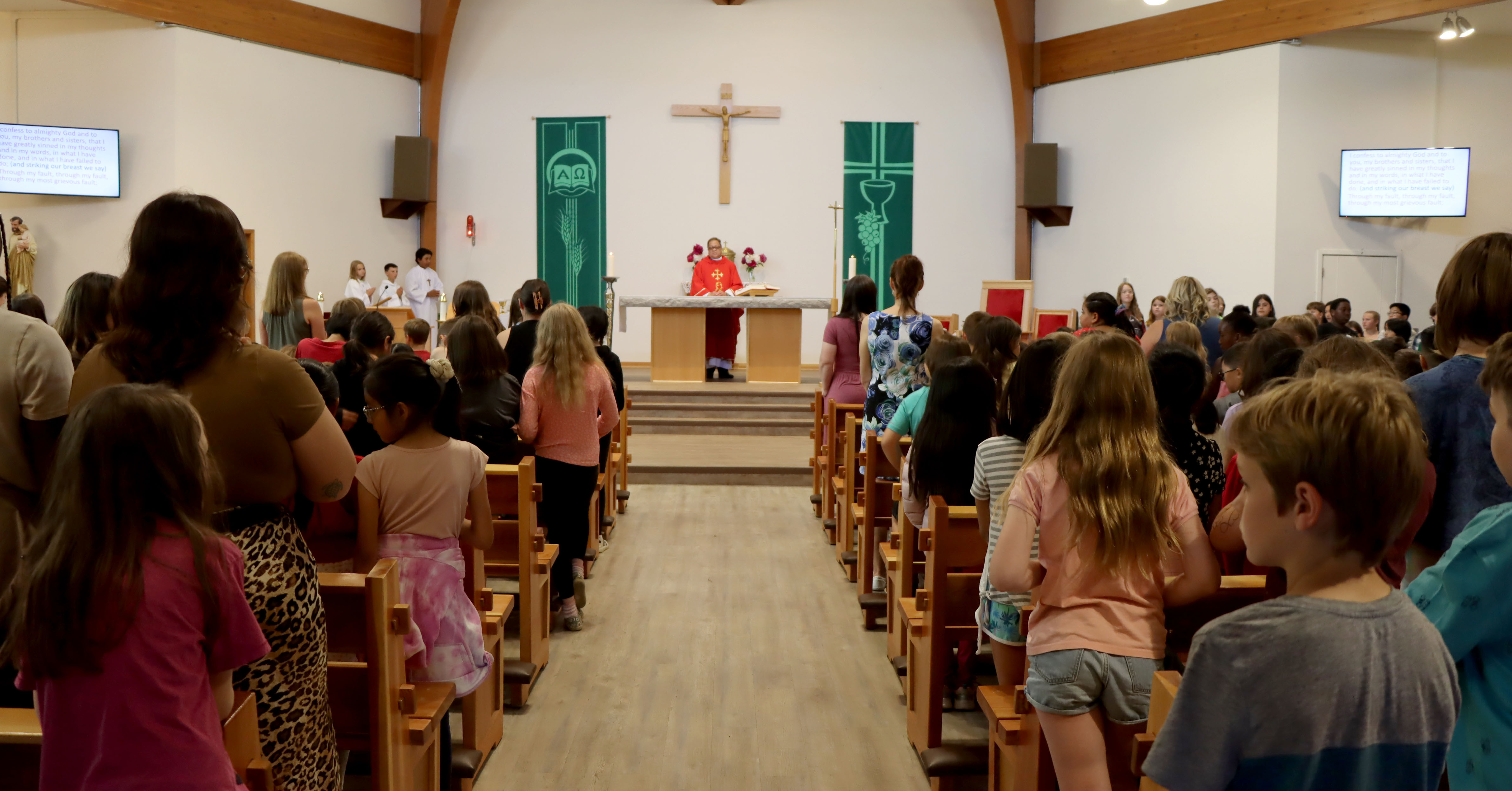 Fr. Nong at front of church with students in pews