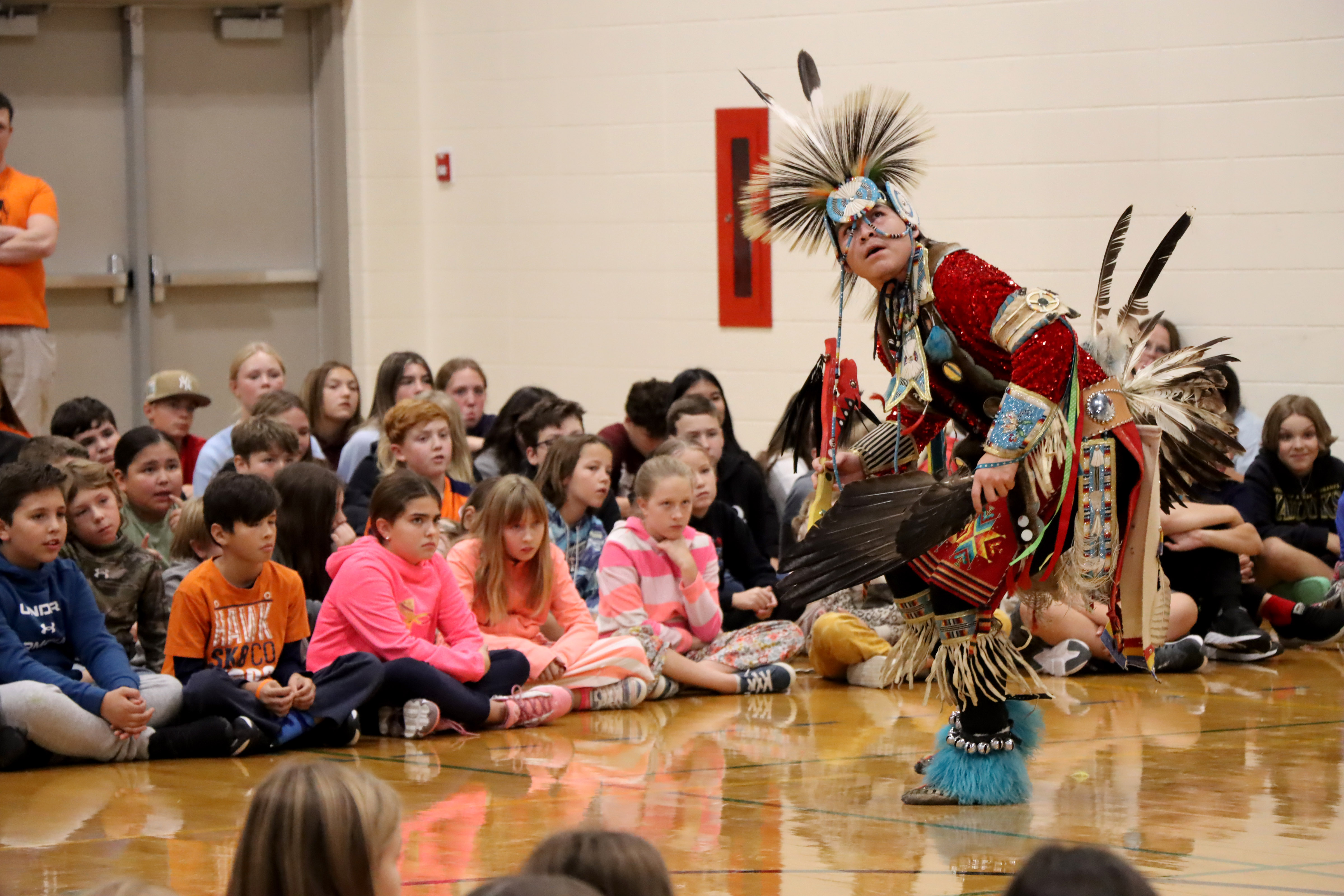 Indigenous dancer performing for students