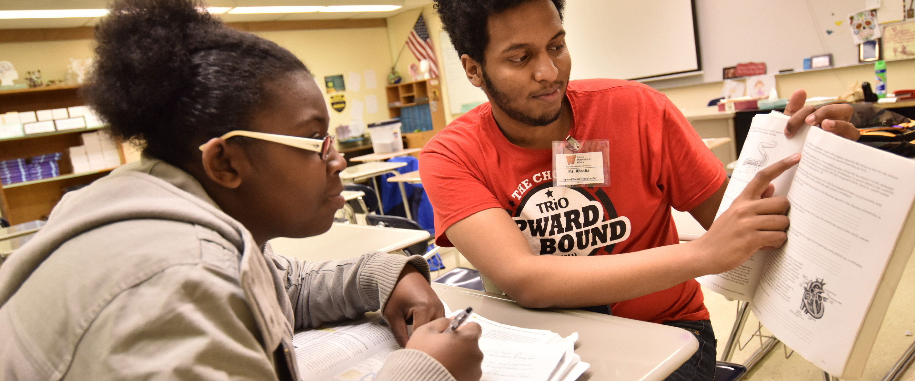 Two students watching a computer