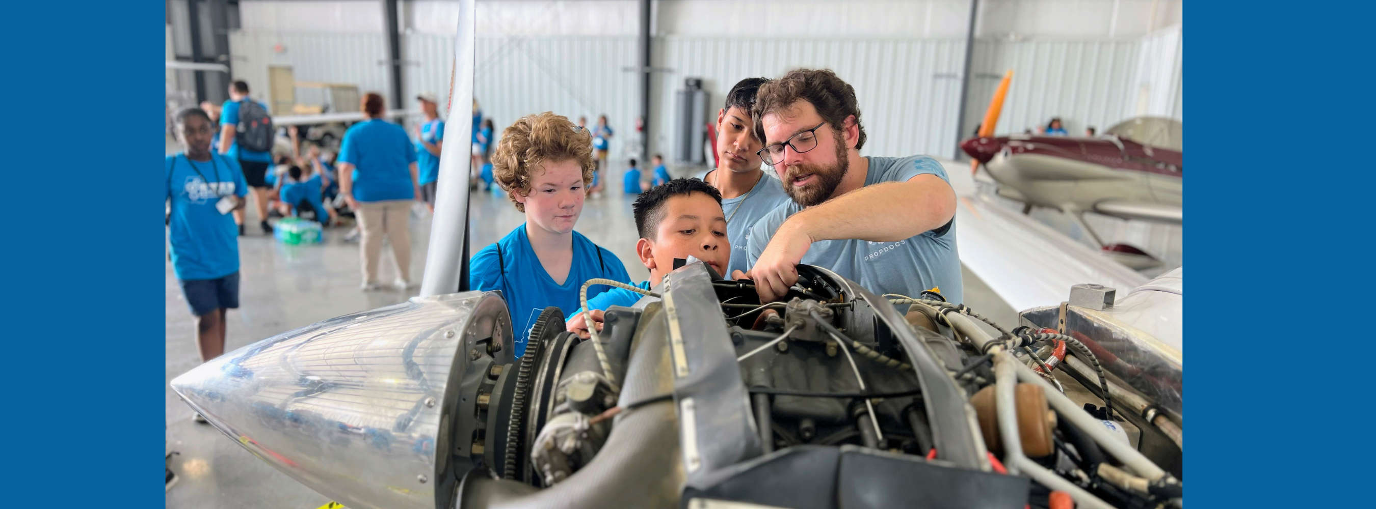 children looking at an airplane engine