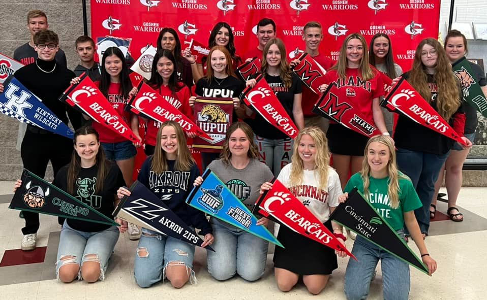 Students holding college pennants