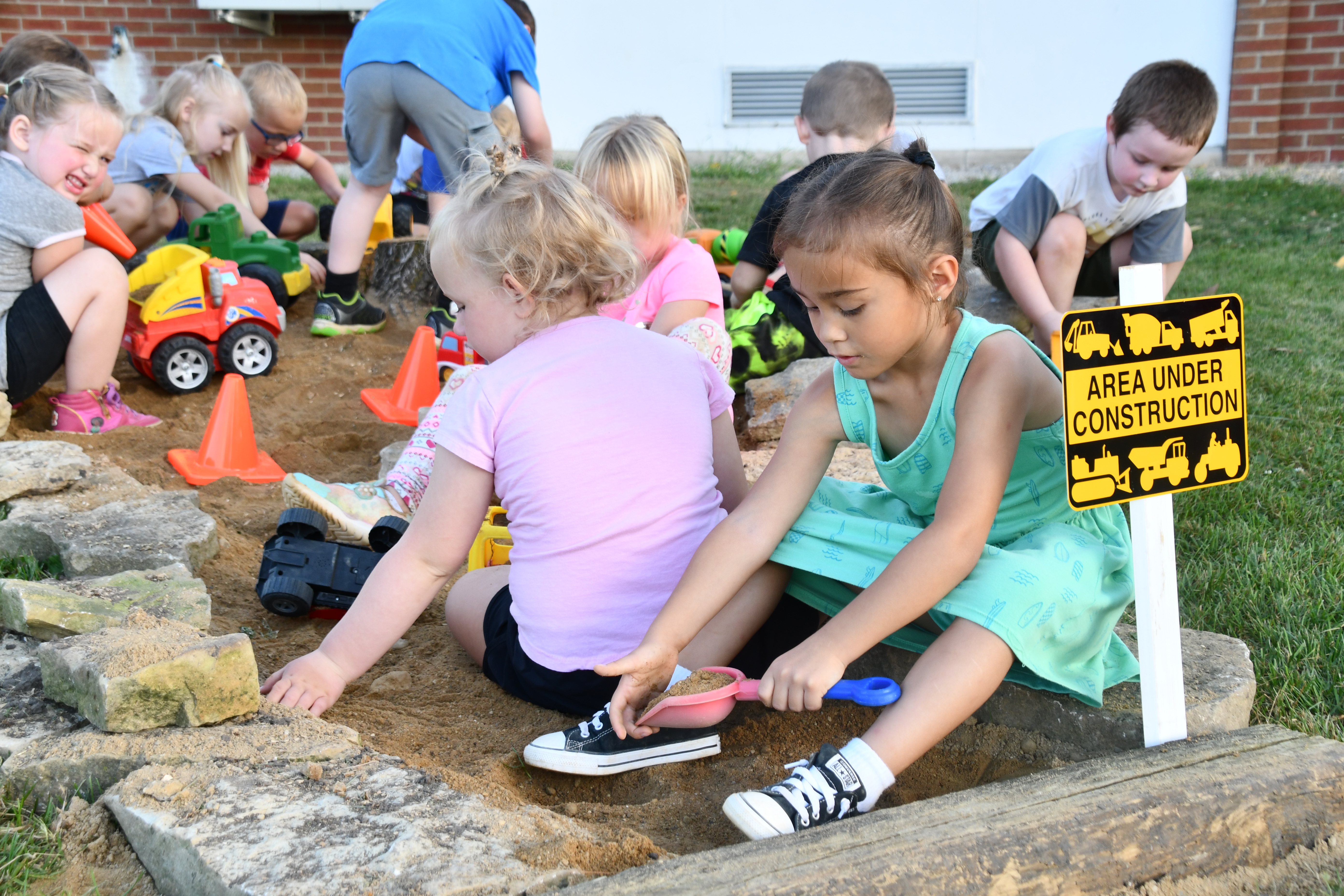 Young students playing in sandbox