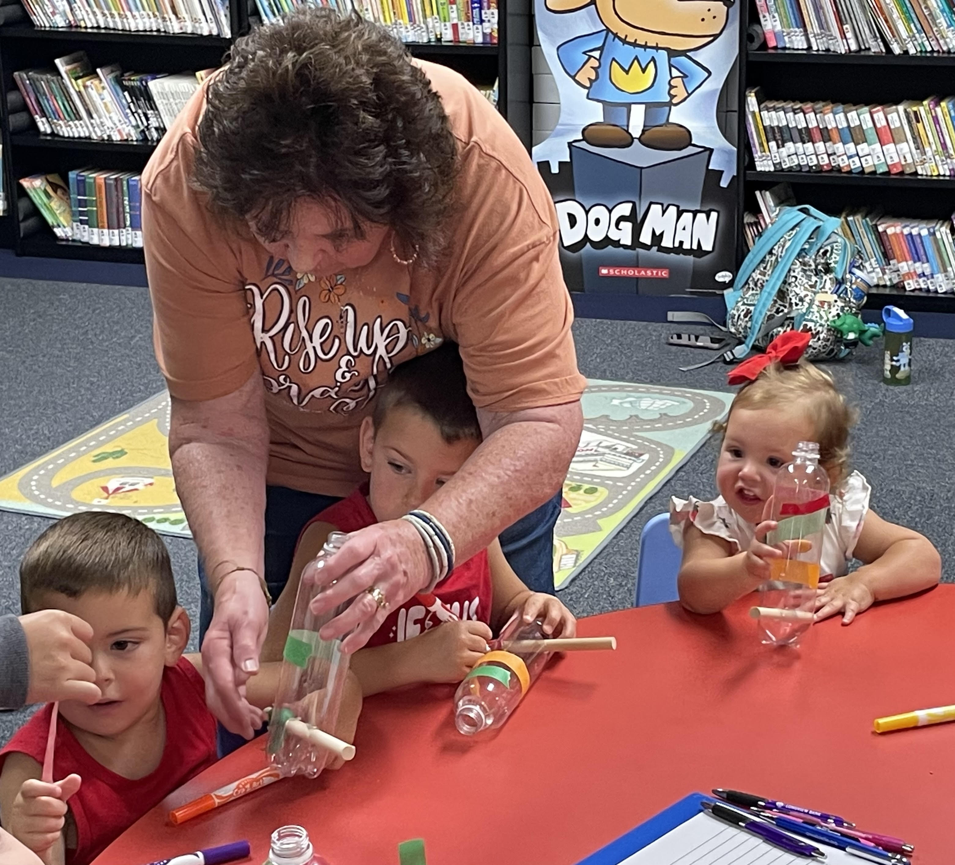 Toddlers building bird feeders with recycled bottles